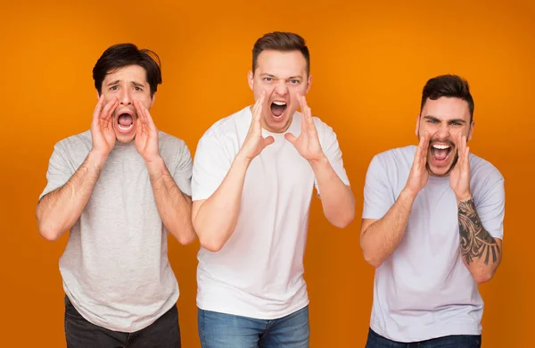 Hombres gritando en voz alta sobre fondo de estudio naranja — Foto de Stock