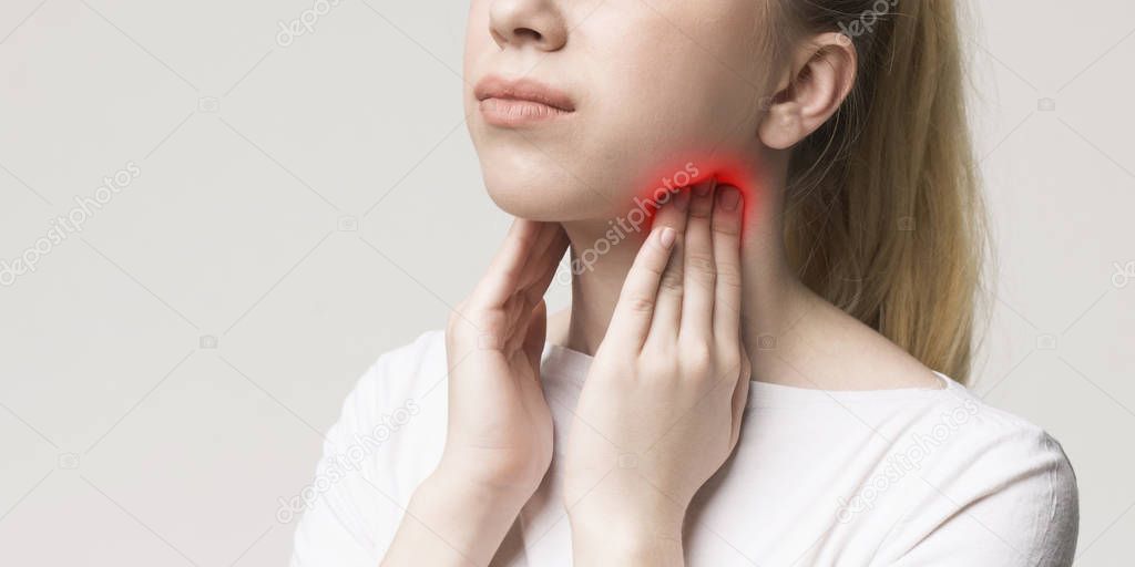 Woman with thyroid gland problem, touching her neck