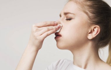 Young woman suffering from nose bleeding, panorama