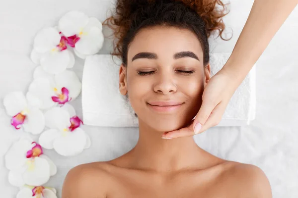 Femme afro-américaine se faire masser le visage au salon de beauté — Photo