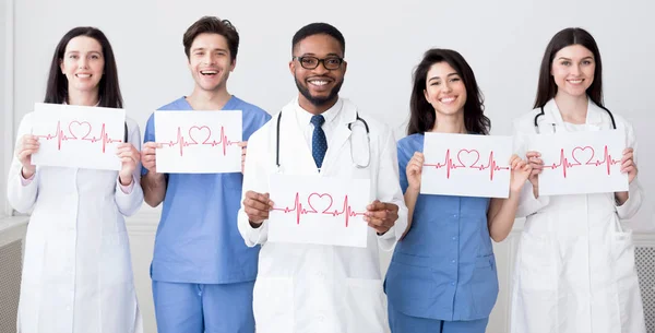 Médicos sosteniendo papeles con cadiogramas de latidos cardíacos —  Fotos de Stock