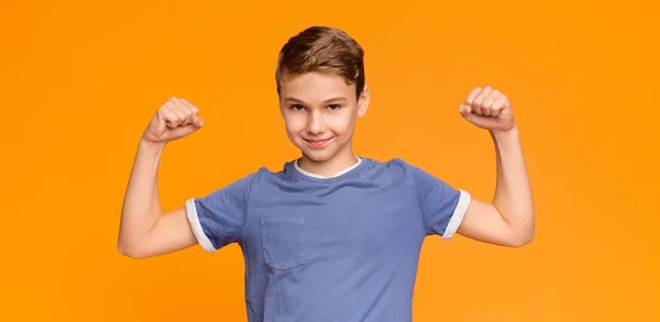 Muchacho sonriente demostrando sus bíceps y músculos — Foto de Stock