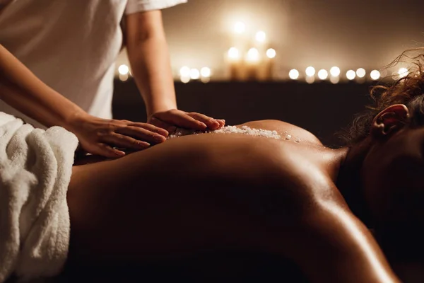 Mulher afro-americana desfrutando de massagem de esfoliação de sal no spa — Fotografia de Stock