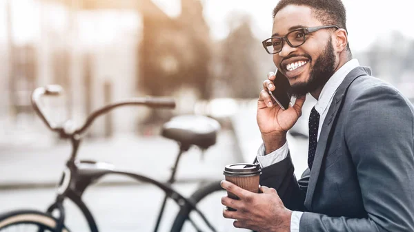 Empresário sorridente falando ao telefone sentado ao ar livre — Fotografia de Stock