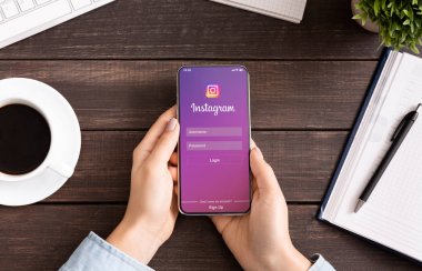 Ekranda Instagram uygulama ile iPhone tutan kadın.