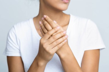 Kadın ellerine nemlendirici krem sürüyor.