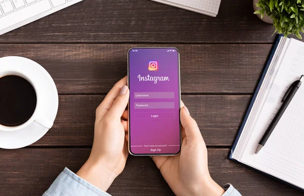 Frau hält Iphone mit Instagram-Anwendung auf dem Bildschirm. — Stockfoto