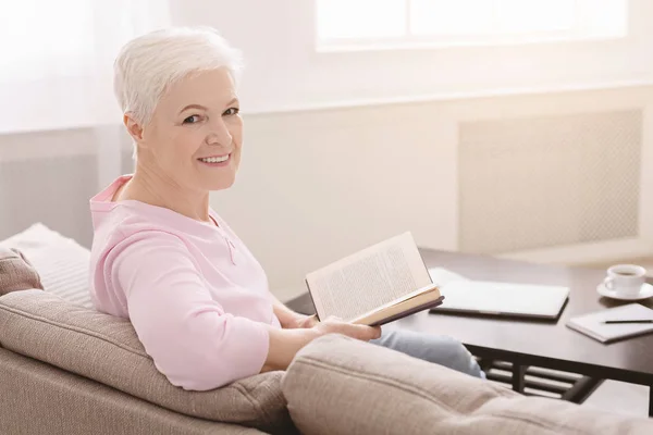 Элегантная пожилая леди расслабляется с любимой книгой — стоковое фото
