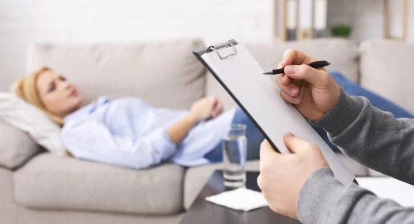 Psicólogo escuchando a paciente deprimido y anotando notas — Foto de Stock