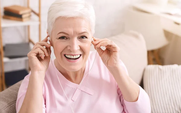 Allegro signora anziana con le cuffie, ascoltando musica — Foto Stock