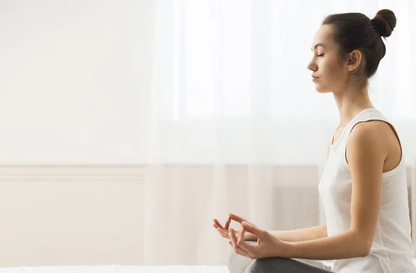 Keep calm. Young woman sitting in lotus position at home — Stock Photo, Image