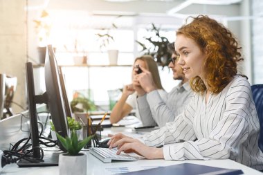 Bilgisayarlarla uğraşan genç çalışanlar.