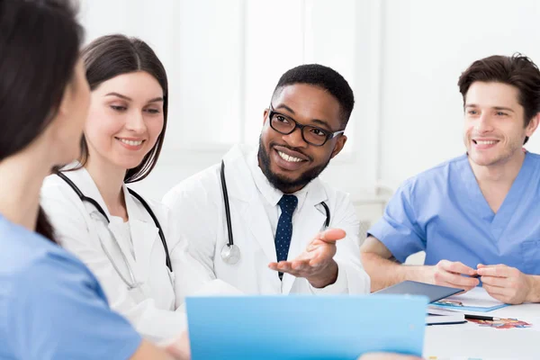 Équipe médicale multiraciale se réunissant, discutant des dossiers des patients — Photo