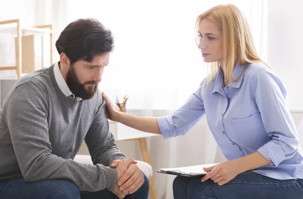 Psychologist comforting sad male patient in office — Stock Photo, Image