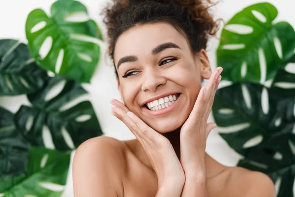 Chica afroamericana con la piel perfecta sobre las hojas tropicales —  Fotos de Stock