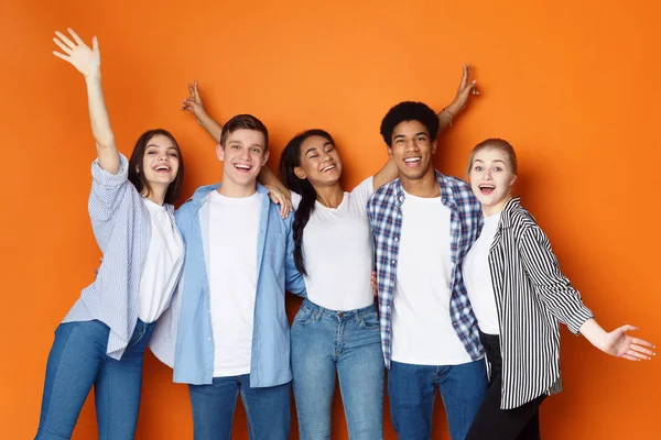 Студенты веселятся на фоне оранжевой студии — стоковое фото