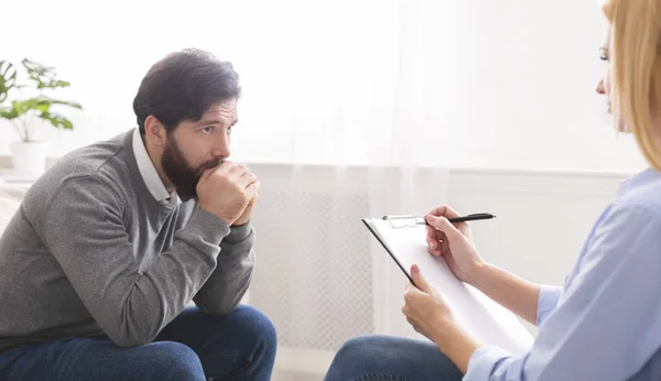 Depressed man getting psychological treatment at clinic