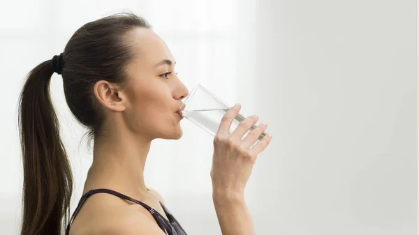 Gezondheidszorg. Meisje drinken schoon mineraalwater, zijdelings uitzicht — Stockfoto