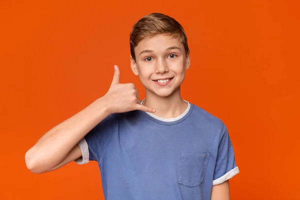 Leuke jongen stak zijn hand aan zijn oor en glimlachen — Stockfoto