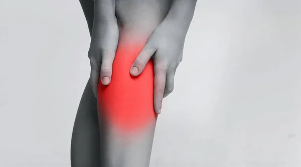 Young woman suffering from pain in leg, massaging inflamed zone — Stock Image Young woman suffering from pain in leg, massaging inflamed zone Stock Photo
