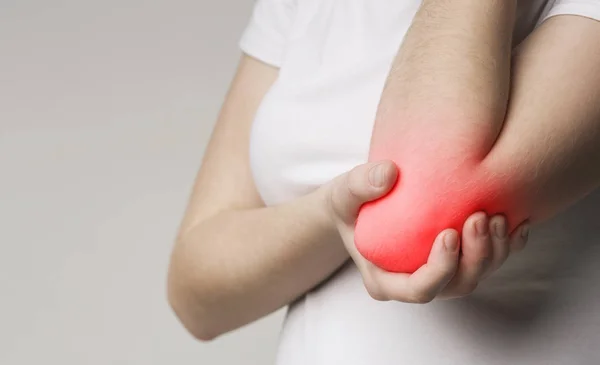 Fecho da mão feminina com cotovelo inflamado vermelho — Fotografia de Stock