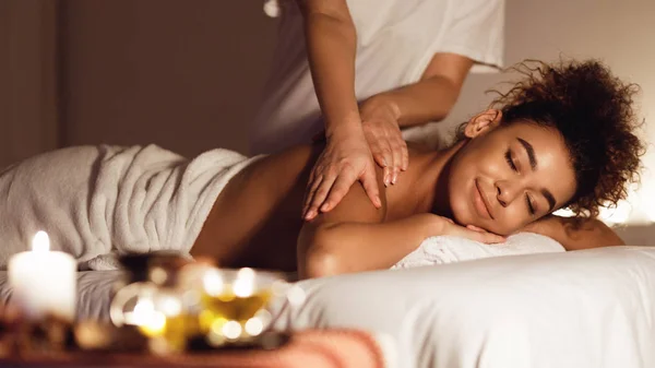 Afro-americana chica disfrutando relajante espalda masaje en spa — Foto de Stock