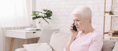 Mutsuz endişeli yaşlı kadın telefonda konuşurken