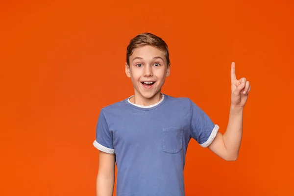 Bonito adolescente menino ter ideia, apontando com o dedo para cima — Fotografia de Stock