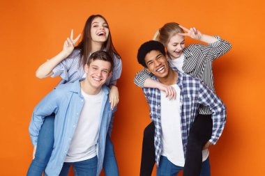 Arkadaşlar eğleniyor. Kızlara piggyback sürüş veren erkekler