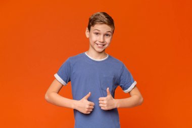 Cool çocuk başparmak yukarıya turuncu jest yapıyor