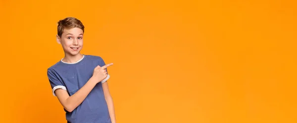 Følelsesmessig tenåringsgutt som peker til side på tomt rom – stockfoto