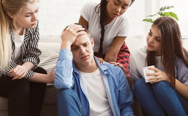 Jóvenes consolando a su amigo molesto en casa —  Fotos de Stock