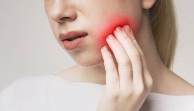 Woman suffering from toothache, touching inflamed cheek clipart