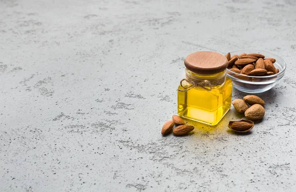 Aceite de almendras y tazón de almendras —  Fotos de Stock