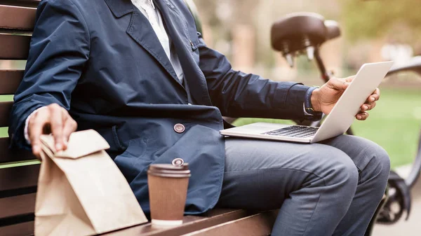 Lunch break. Businessman sitting outdoors with laptop