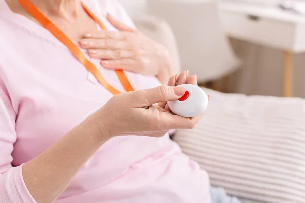 Senior vrouw gevoel hart pijn en dringende noodoproep knop — Stockfoto