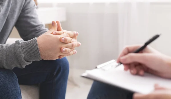 Therapist writing notes during counseling session with single man — Stock Photo, Image