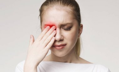 Upset woman suffering from strong eye pain clipart