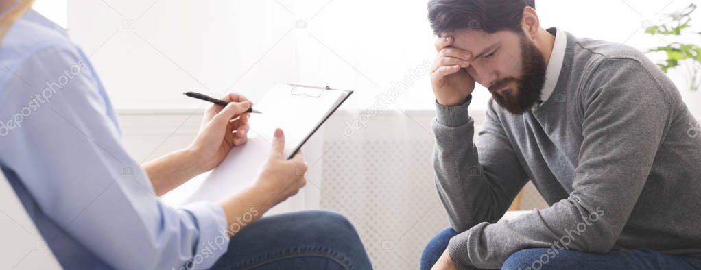 Depressed man discussing family problems with psychotherapist
