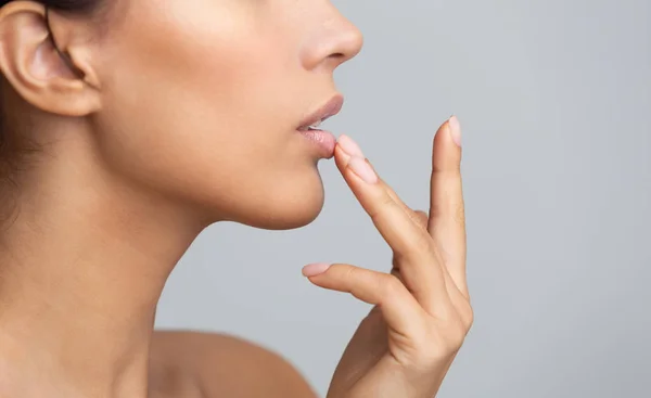 African woman in profile touching her lips — Stock Photo, Image