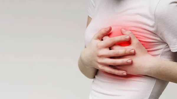 Woman clutching her chest, acute pain as possible heart attack — 스톡 사진