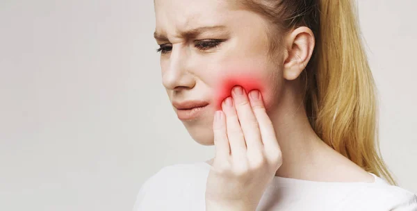 Frustrato giovane donna con mal di denti toccare la guancia — Foto Stock