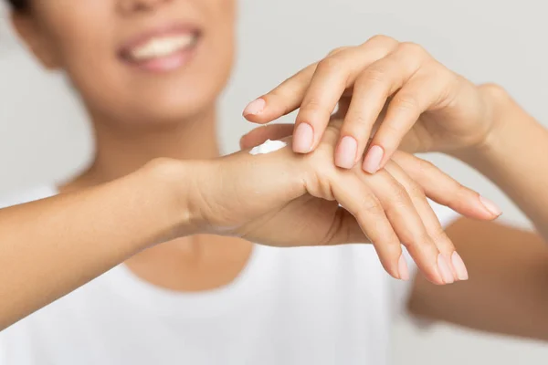 Cuidado com a pele. Mulher feliz aplicando creme hidratante da mão — Fotografia de Stock