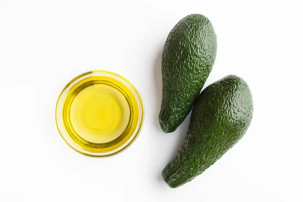 Ripe avocadoes and oil on white — Stock Photo, Image