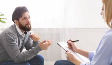 Yakışıklı genç adam kanepede oturan ve psikolog konuşuyor