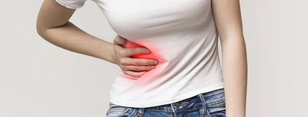 Woman in pain holding her stomach on right side — Stock Photo, Image