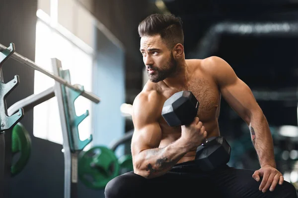 Homem musculoso forte fazendo exercícios com halteres — Fotografia de Stock