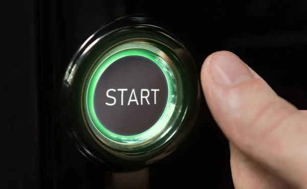 Hombre pulsando el botón verde iluminado con la palabra Inicio — Foto de Stock