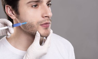 Kendine güvenen genç adam yanak-kemik dolgu enjeksiyonu olan