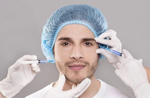 Hombres cara y esteticistas manos con jeringas haciendo inyecciones de belleza — Foto de Stock